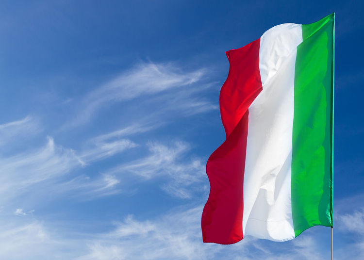 Low angle view of italian flag against blue sky