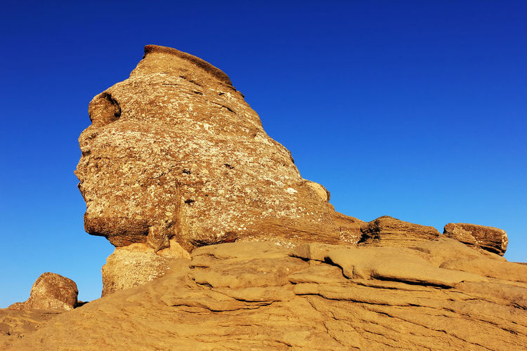 Sphinx of rock formations against clear blue sky