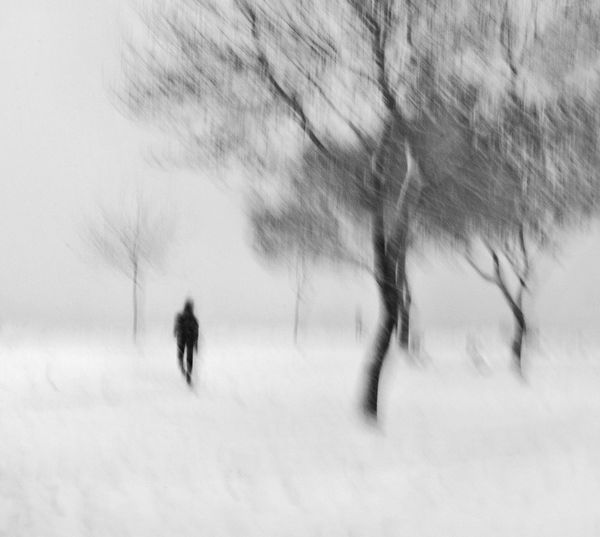 Blurred motion of people walking on snow covered field