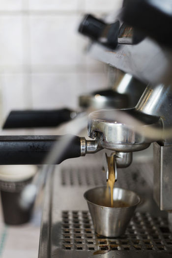 Close-up of coffee pouring in cup on machine