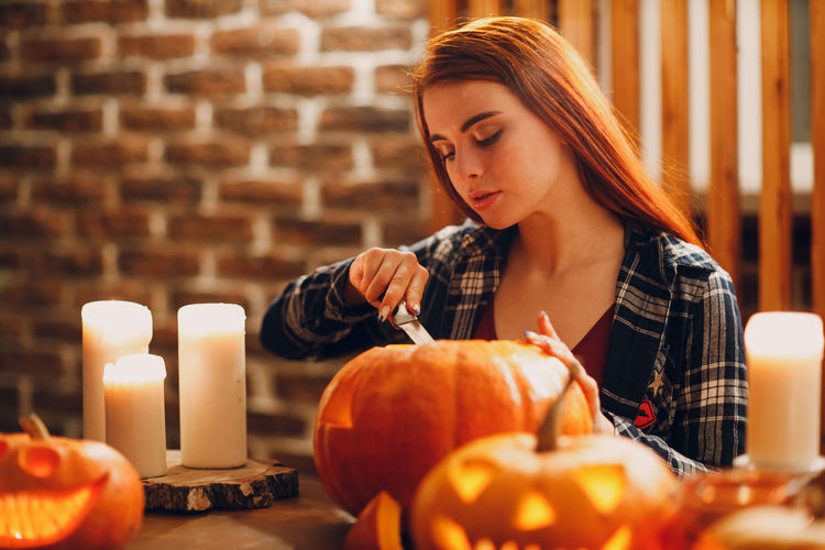 Portrait of young woman with jack o lantern