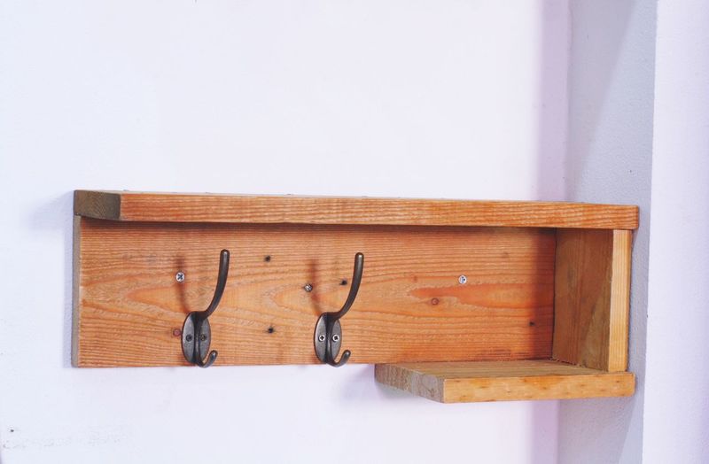 Close-up of hooks on shelf at wall