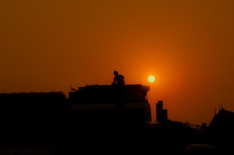 Silhouette building against sky during sunset