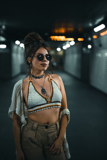 Young woman wearing sunglasses standing at night