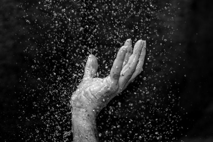 Close-up of woman hand with water drops