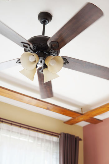 Low angle view of electric fan hanging from ceiling