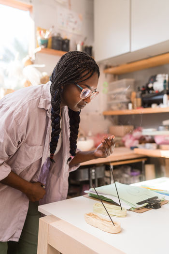 Woman with braided hair lighting up incense
