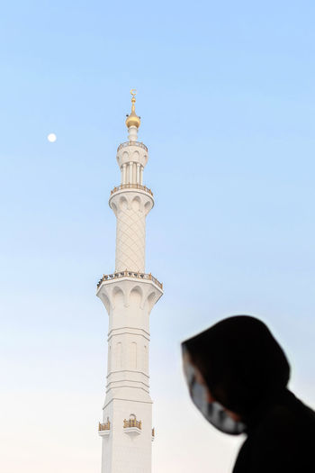 Silhouette of muslim woman, covered in black abaya in grand mosque