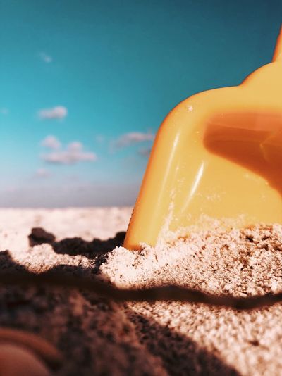 Close-up of shovel in sand at beach