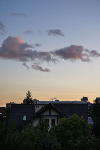 Houses and buildings against sky at sunset