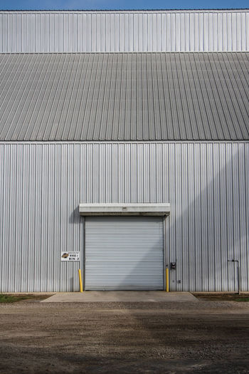 Industrial building on field against sky
