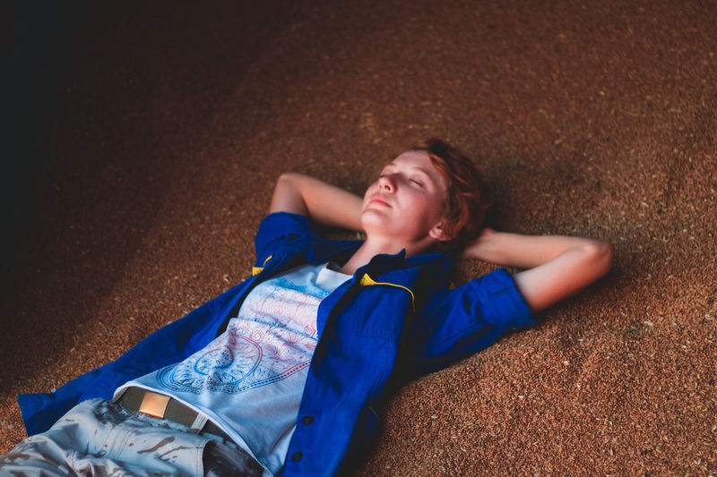 High angle view of young woman relaxing on wheat