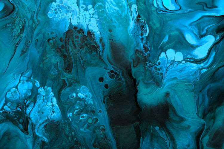 Fluid art. blue abstract wave swirls on black background. marble effect background or texture