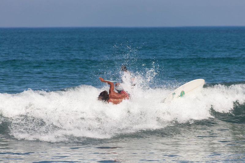 View of man surfing in sea against sky