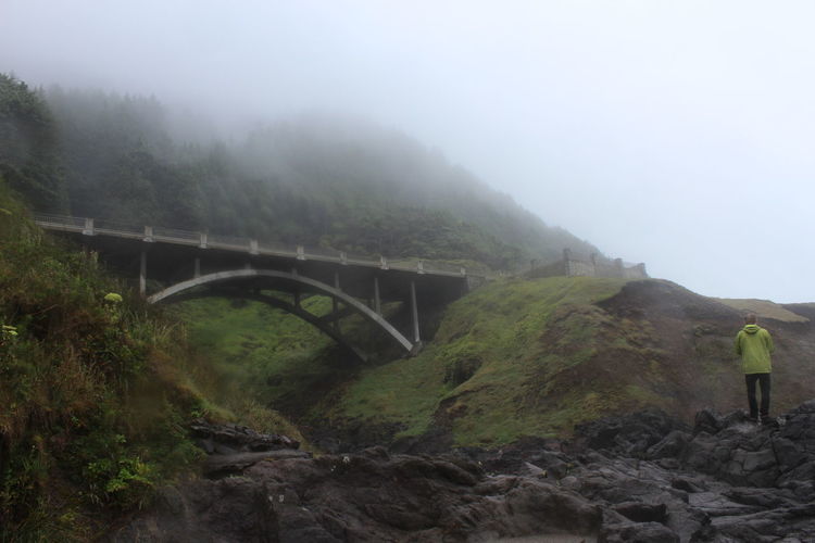Bridge over landscape against sky during foggy weather