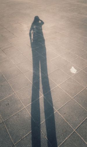 Low section of man standing on shadow