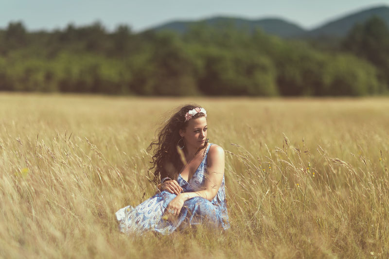 Beautiful woman sitting on grassy field 