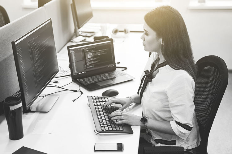 Midsection of woman using laptop on table