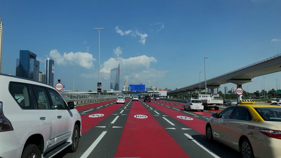 Traffic on road in city against sky