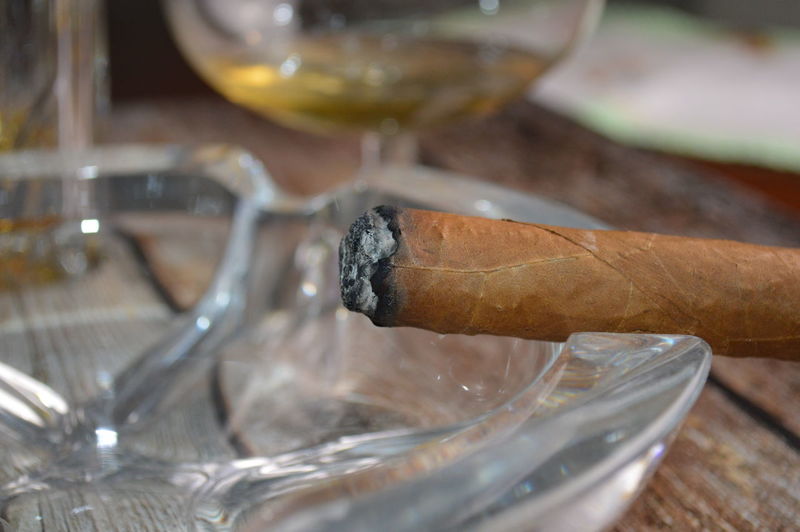 Close-up of cigarette with alcohol on table