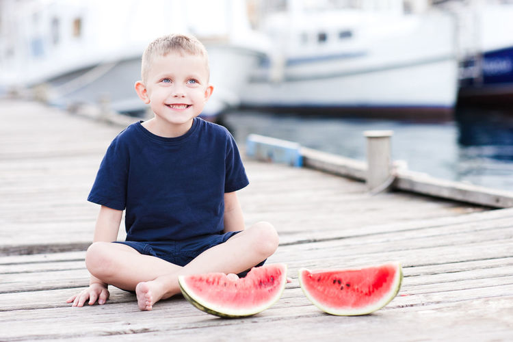 Smiling kid boy 4 year old eating fresh watermelon outdoors. happy child.