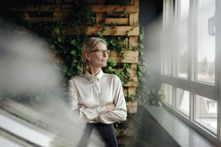 Businesswoman in green office looking out of window