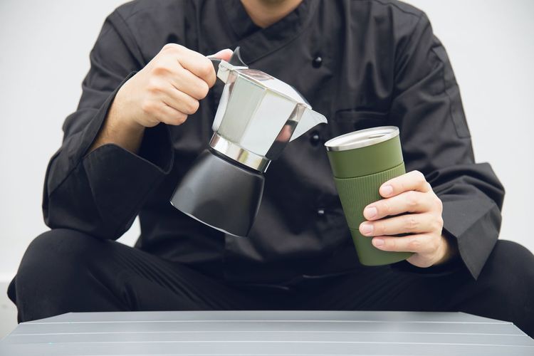 Midsection of man holding coffee