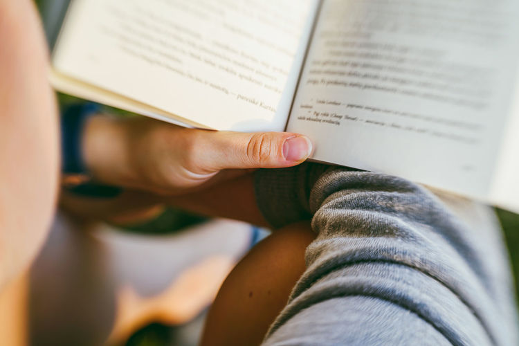 Cropped image of person reading book
