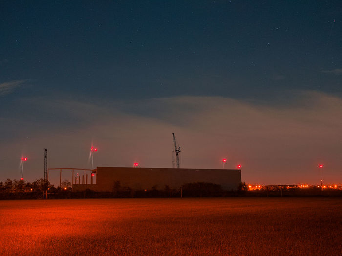 Scenic view of illuminated field against sky at night
