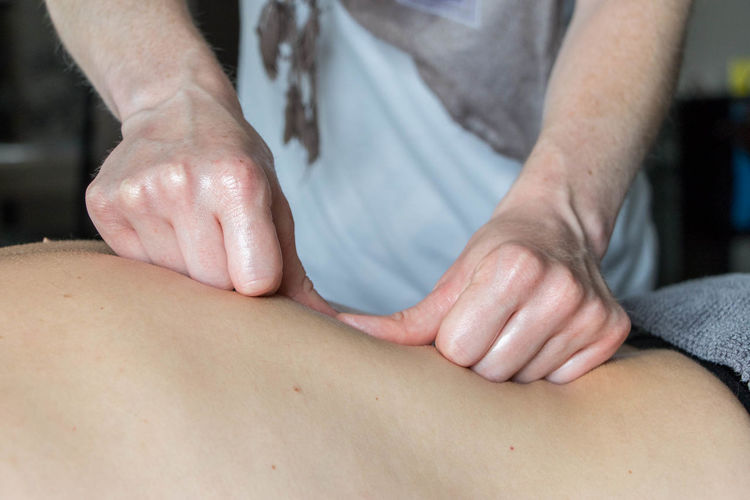 Midsection of physical therapist giving massage to patient