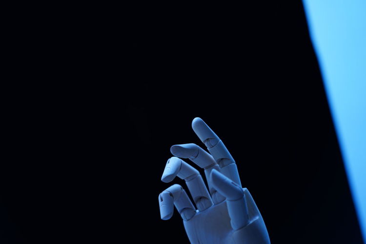 Figurine hand against colored background