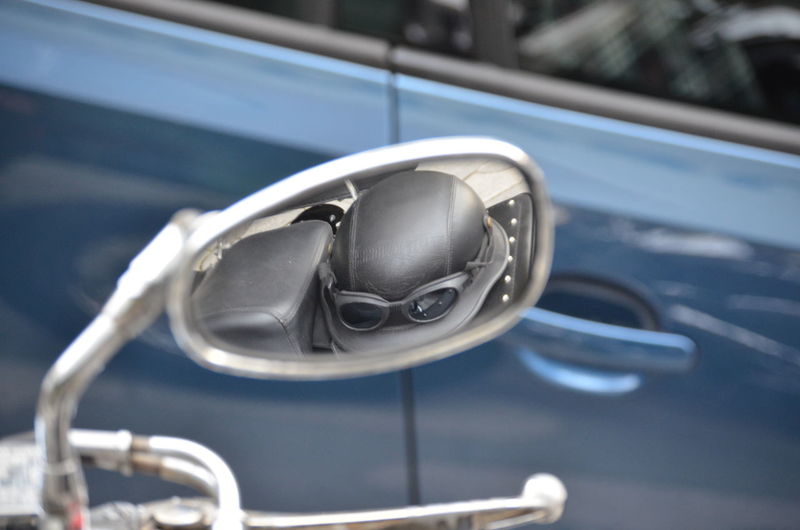 Close-up of vintage motorcycle mirror and reflection of the helmet