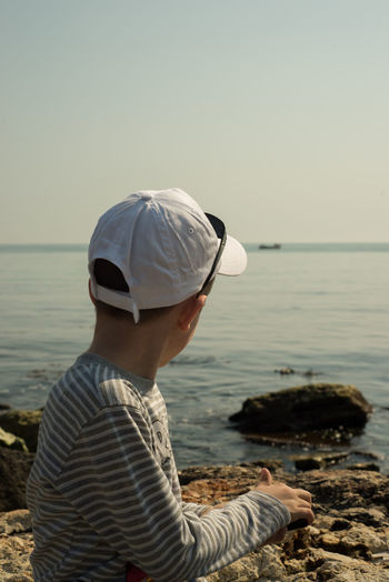 Side view of boy looking at sea during summer