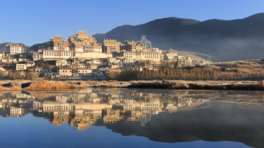 Songzanlin monastery by lake against mountains