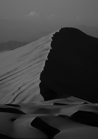 Sand dunes in desert against clear blue sky