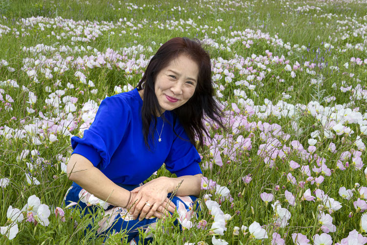 Portrait of a smiling young woman in flower field