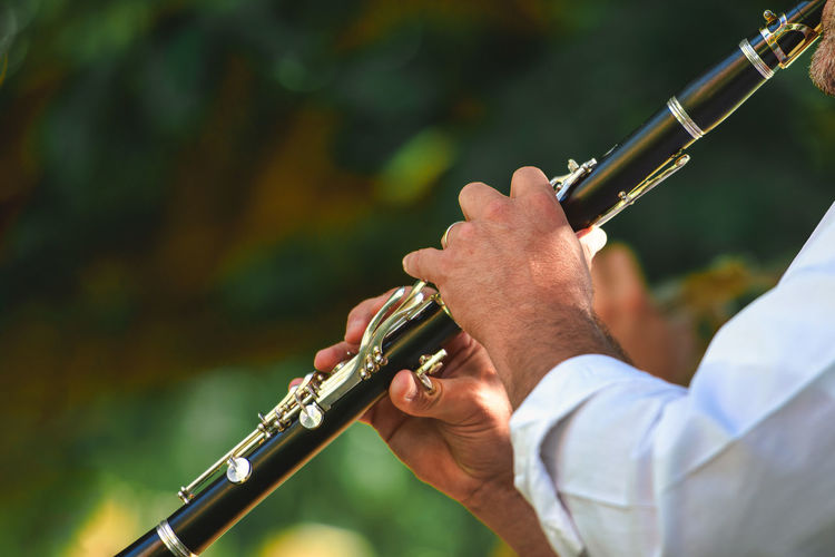 Midsection of man playing wind instrument