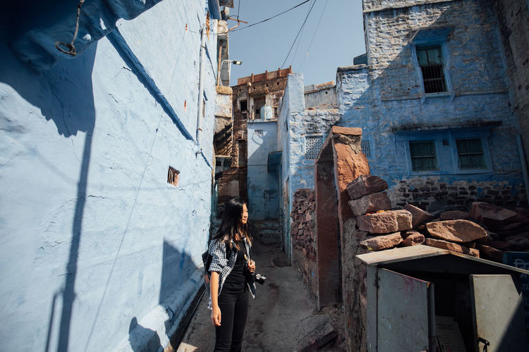Woman standing amidst buildings in city