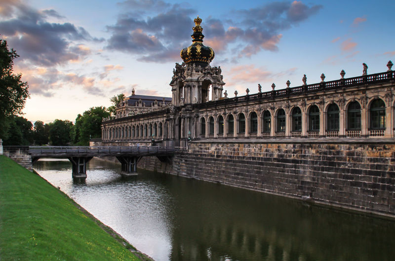 Zwinger by river against sky during sunset in city