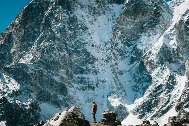 Man standing on rocky mountain during winter