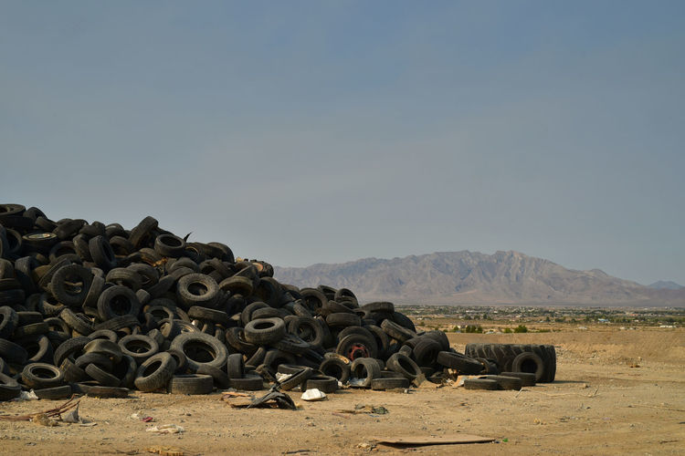 Worn-out vehicle tires piled in mojave desert with distant mountains in pahrump, nevada, usa