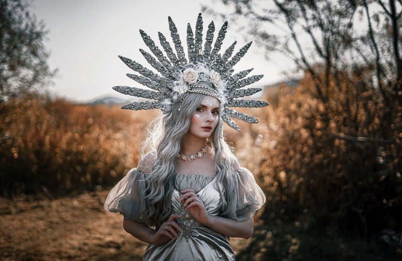 Portrait of woman wearing costume standing on field