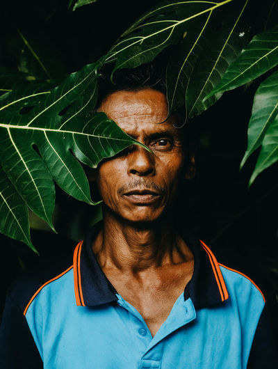 Portrait of man with woman standing by leaves