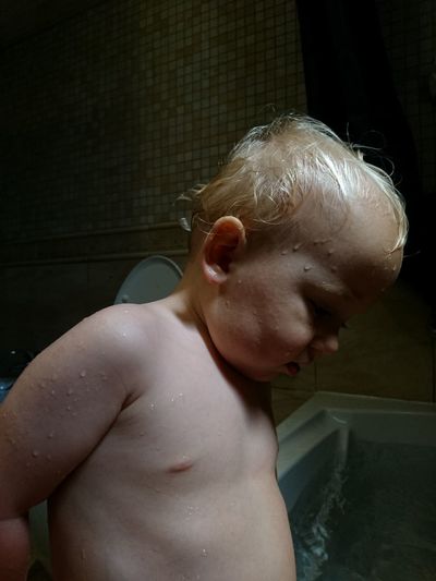 Full length of shirtless boy in bathroom