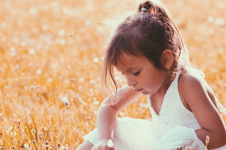 Close-up of girl sitting on field