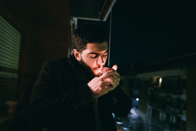Portrait of young man standing at night