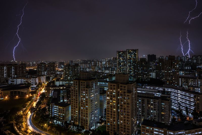 Illuminated cityscape against sky at night