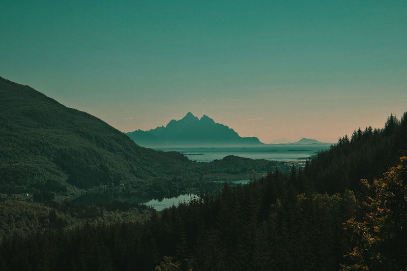 Scenic view of silhouette mountains against clear sky at sunset