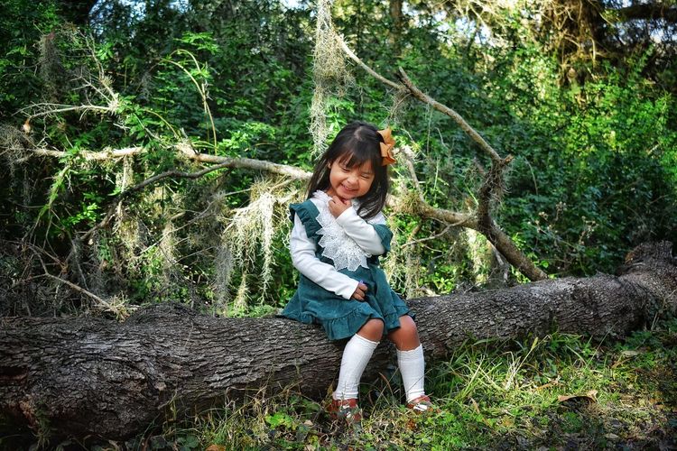 Full length of smiling girl in forest