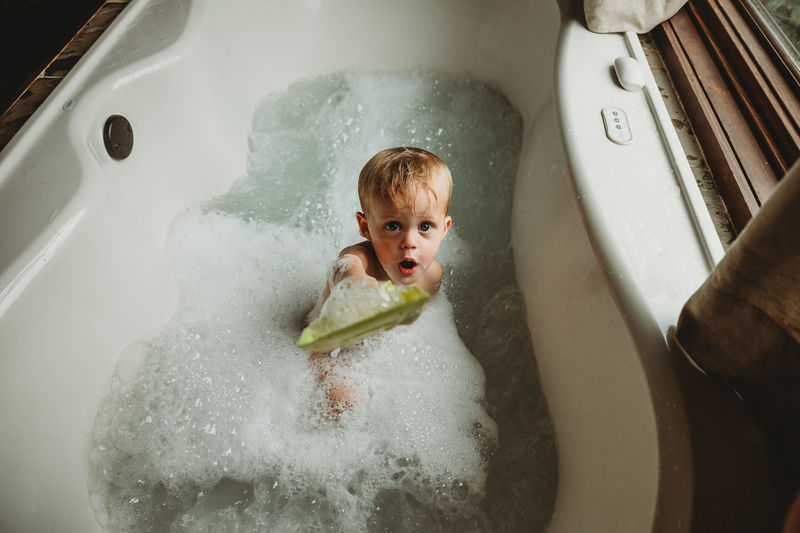 Toddler boy playing in bubble bath
